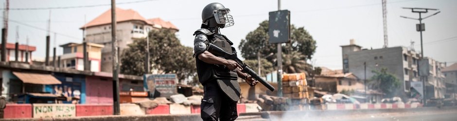 A policeman stands along the "axis of democracy" as protests broke out in Conakry on February 29, 2020. - Guinea's President Alpha Conde announced on February 28, 2020 a "slight postponement" of March 1's referendum on whether to adopt a new constitution, following mounting international criticism over the poll's fairness.