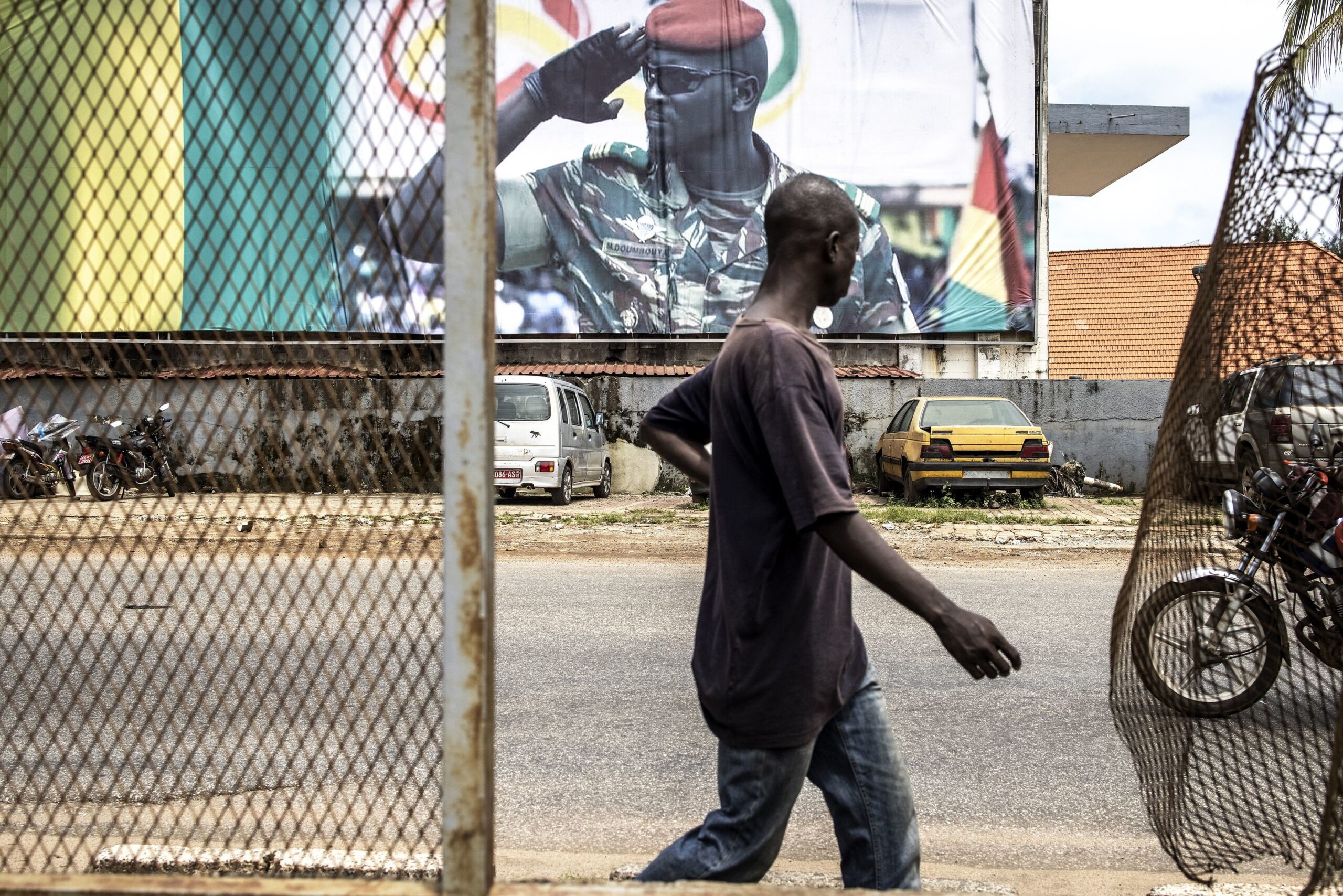 A man walks past a billboard showing junta leader, Colonel Mamady Doumbouya, in Conakry on September 11, 2021. Doumbouya's special forces on September 5, 2021 seized Alpha Conde in a Coup, the West African state's 83-year-old president, a former champion of democracy accused of taking the path of authoritarianism.